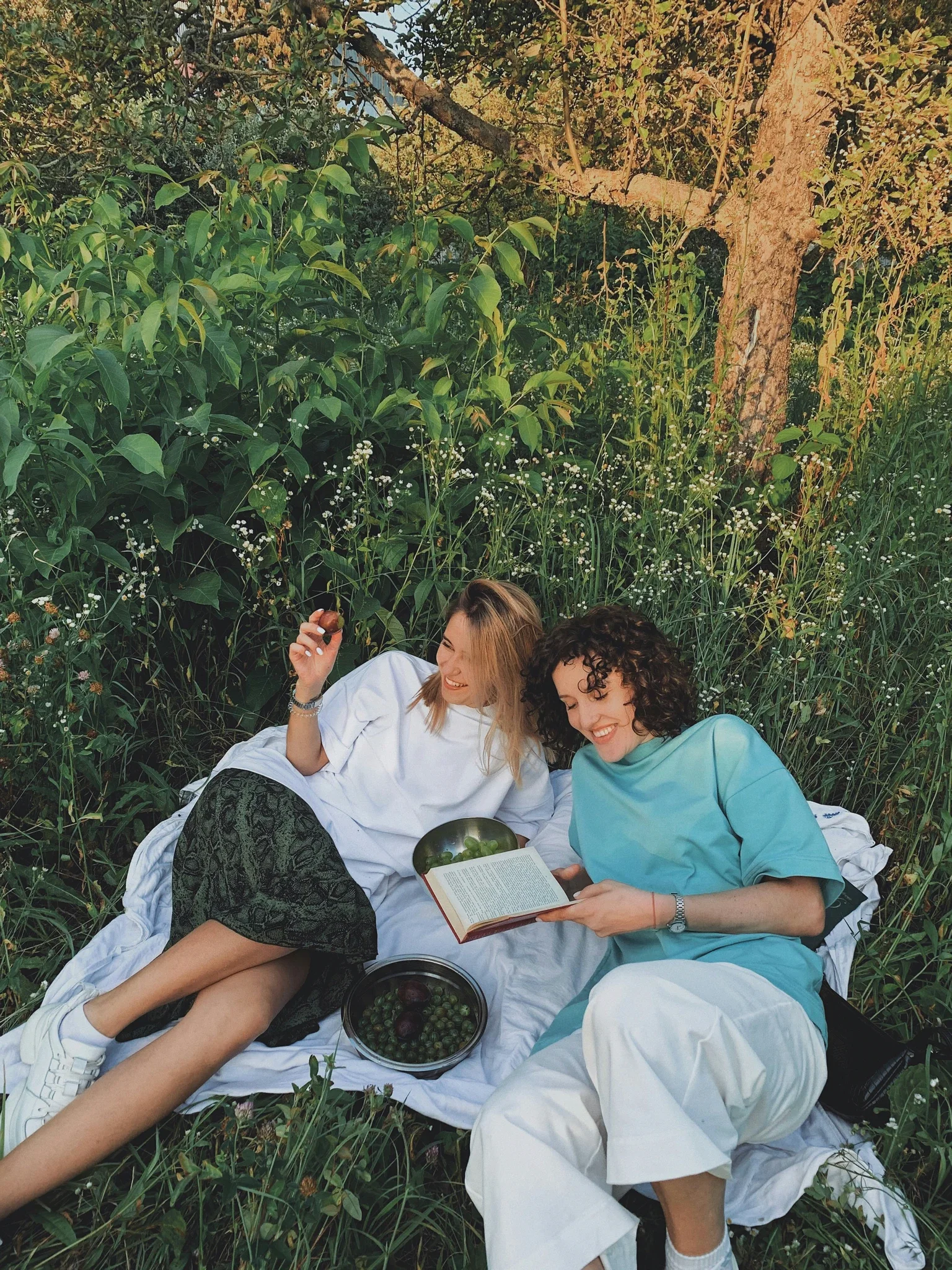 Two women sharing a relaxed outdoor moment, symbolizing reduced anxiety and nervous system calm