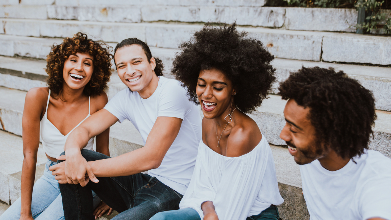 Group of friends sitting together and laughing, representing connection and support in depression therapy.