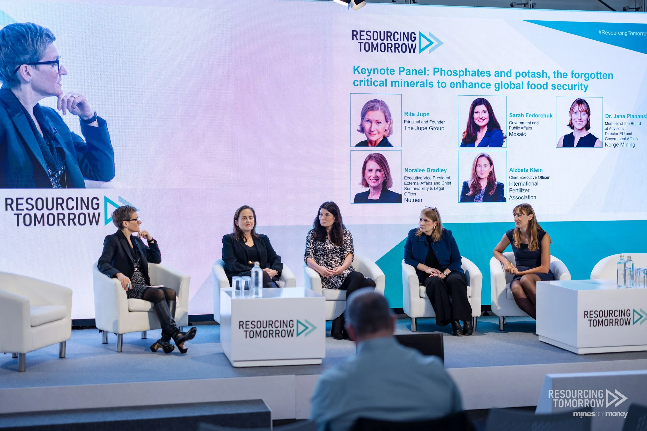 Rita Jupe moderates a panel discussion about the importance of fertilizers. Five women are seated on the stage at the Resourcing Tomorrow conference in London, UK.