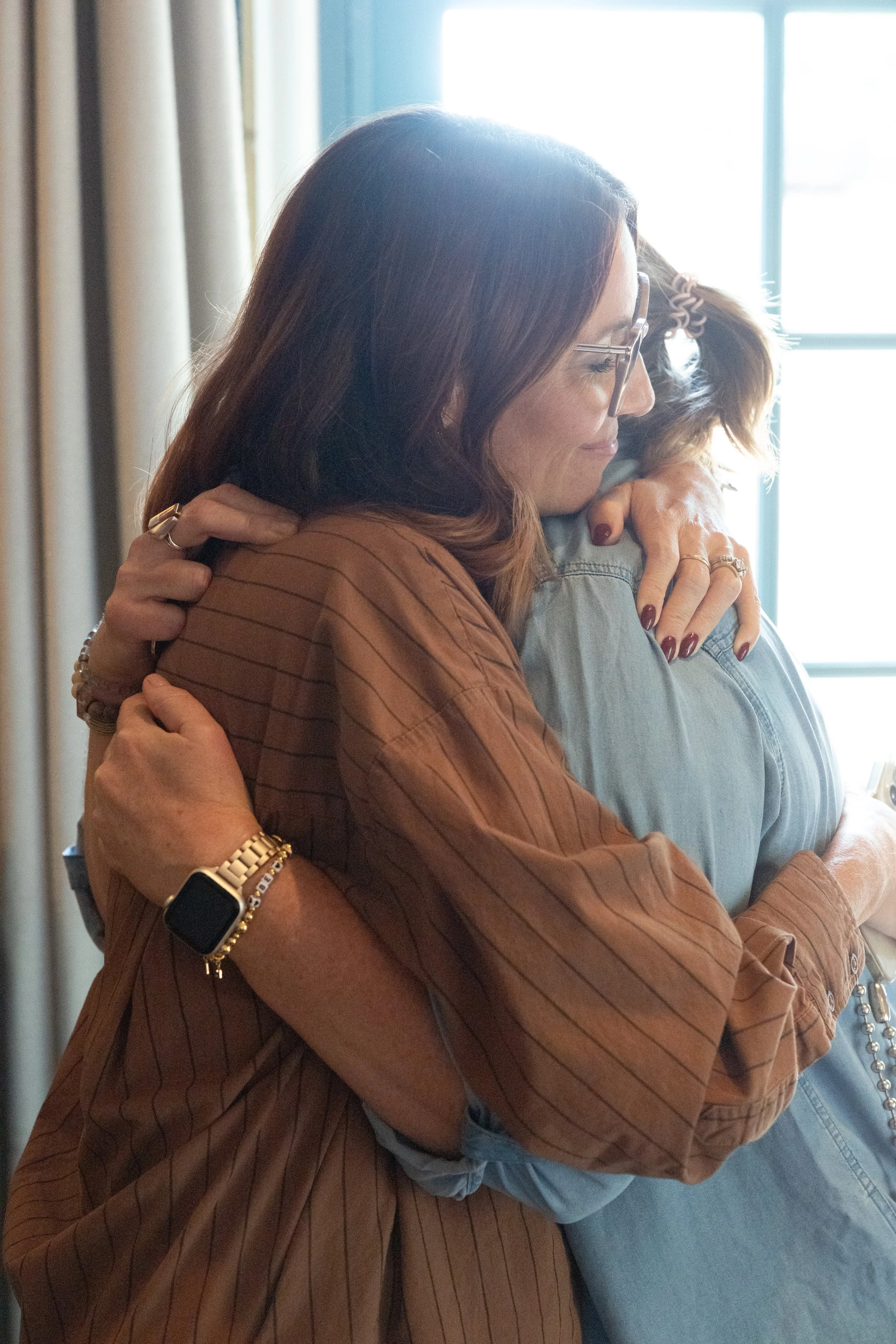 Two women hugging after leadership retreat planning.