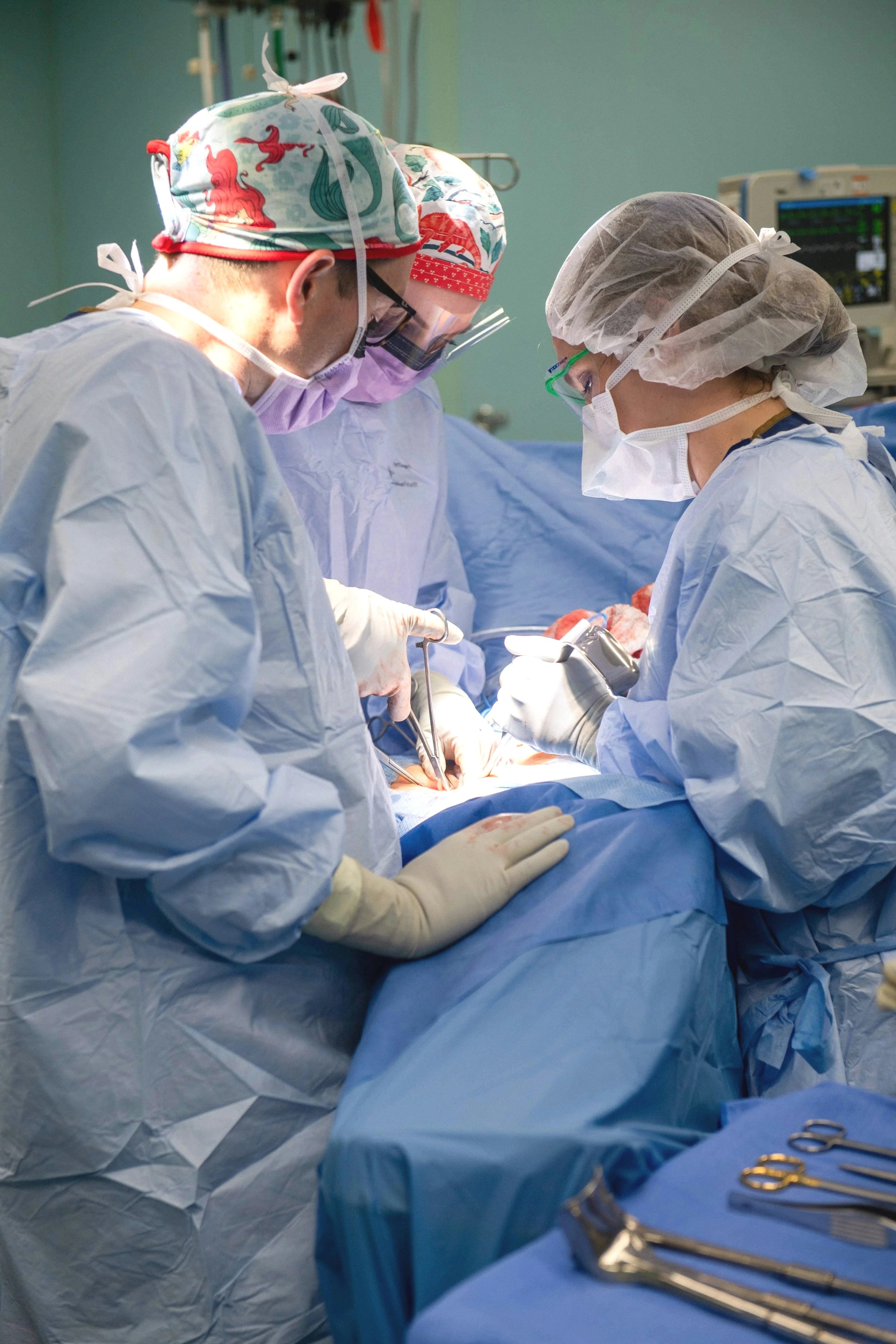 Medical professionals performing surgery in an operating room.