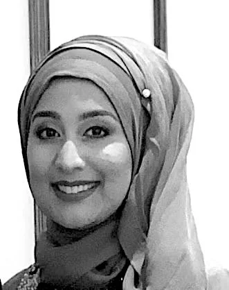 A woman wearing a headscarf smiling at the camera.