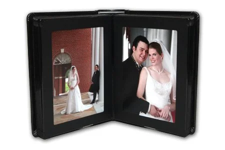Open photo album showing a bride in a white wedding dress and a groom in a black tuxedo at a wedding ceremony.