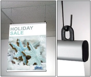 A holiday sale advertisement hanging from the ceiling and a toilet paper roll on a holder.