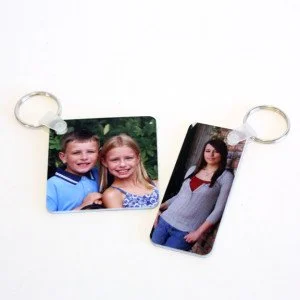 Two keychains, one with a photo of a young boy and girl, the other with a photo of a woman.