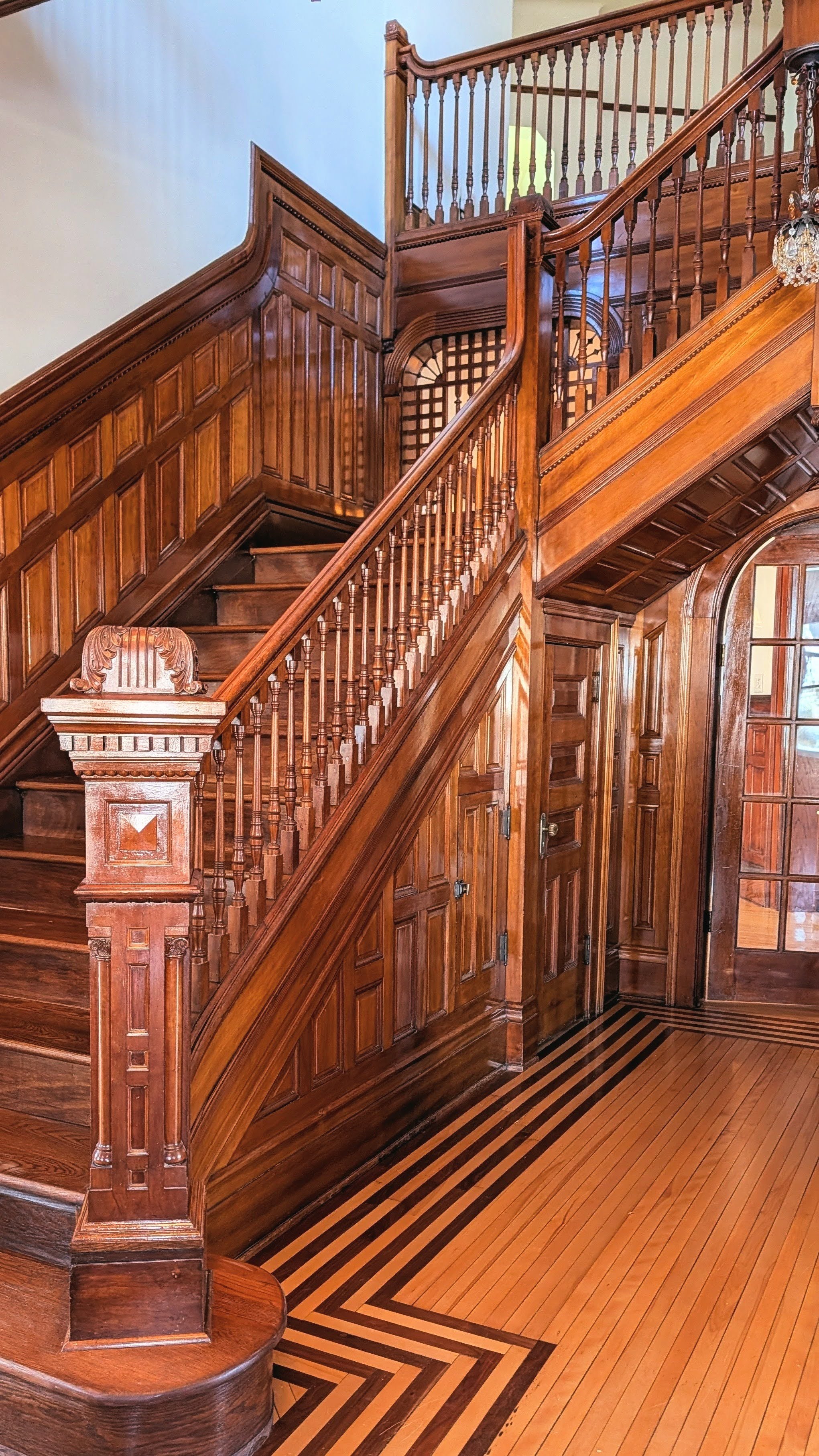 Warm wood and ornate details on the historic banister and staircase at the Moore House 