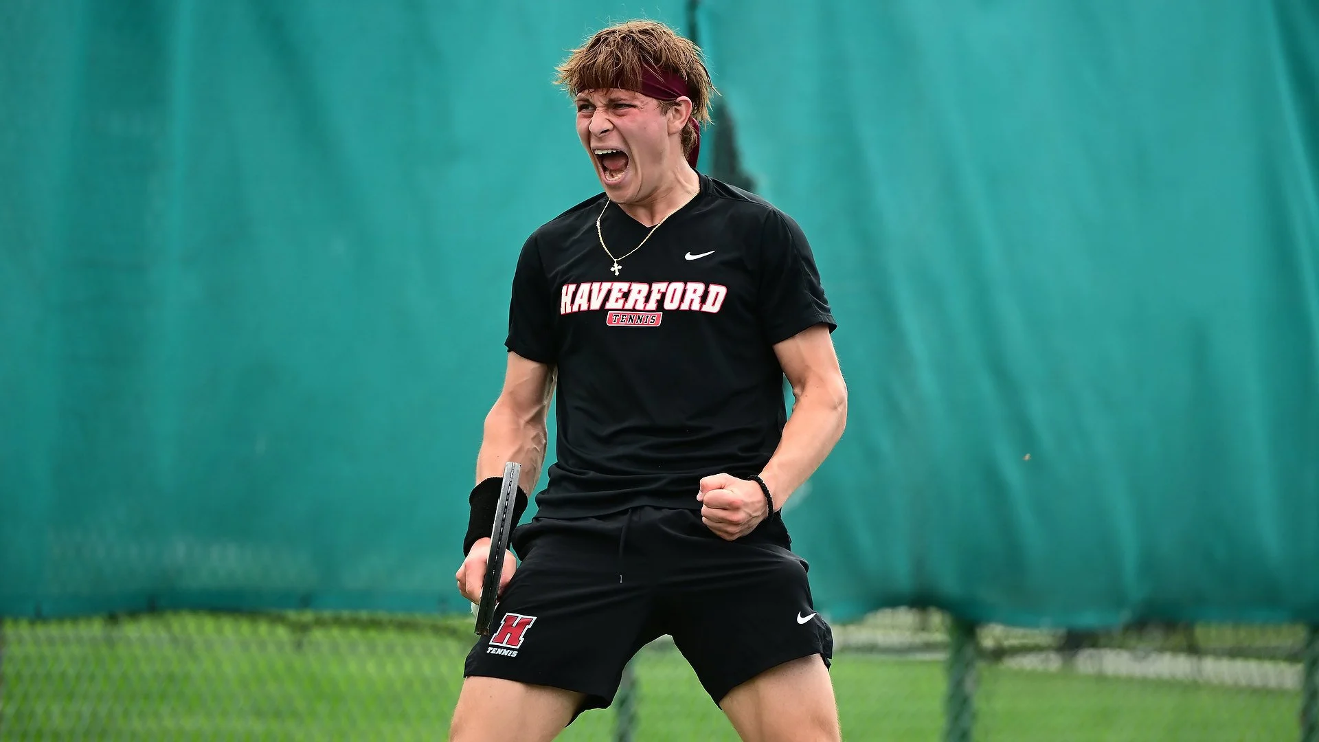A Haverford men's tennis player celebrates with a yell during a tennis match.