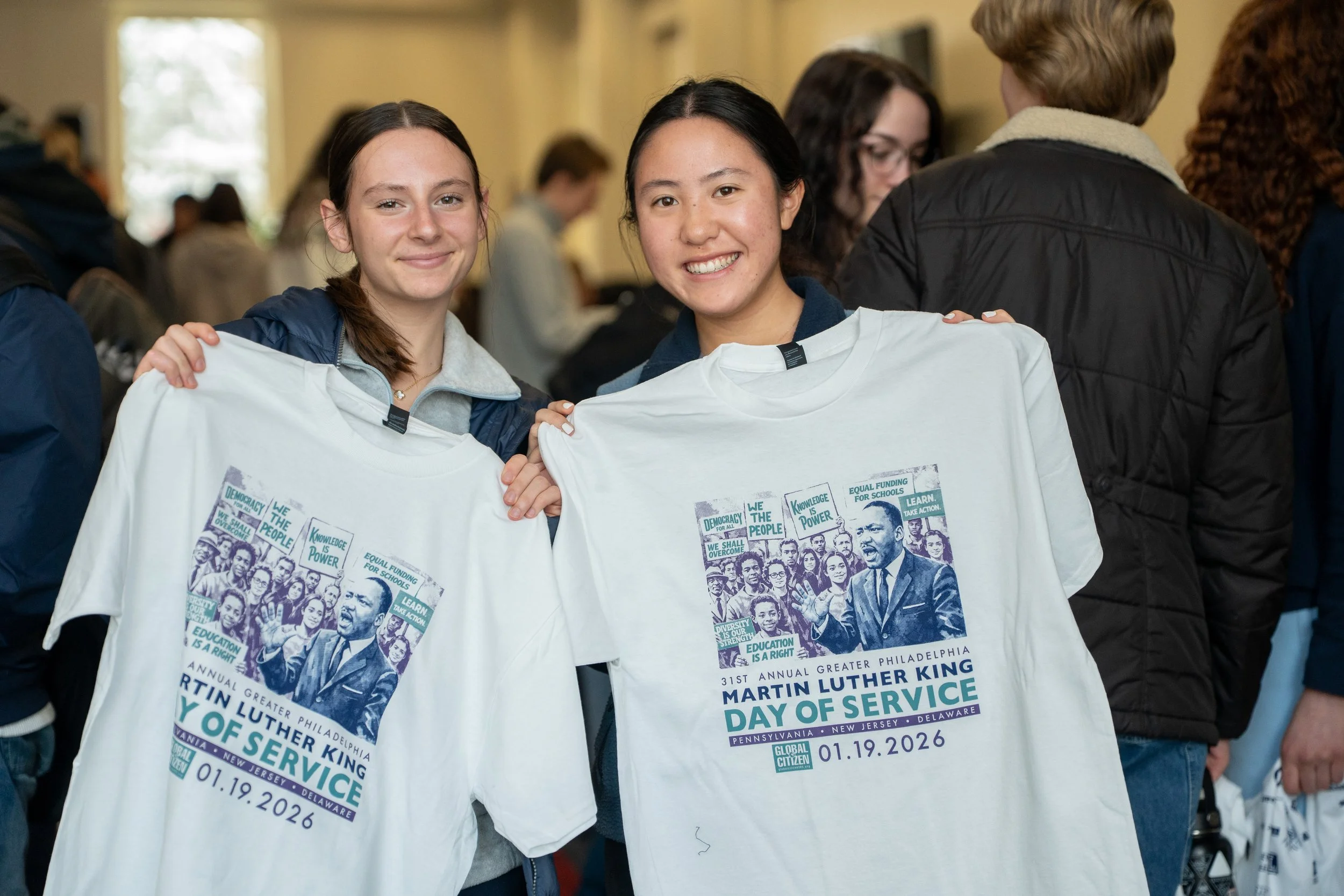 Two Haverford students hold white T-shirts at the Martin Luther King Day of Service event, with the event details printed on the shirts indicating it's the 31st annual event in Greater Philadelphia, on January 19, 2026.