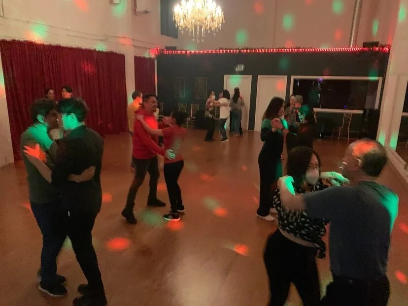 a party with partner dancers in a ballroom
