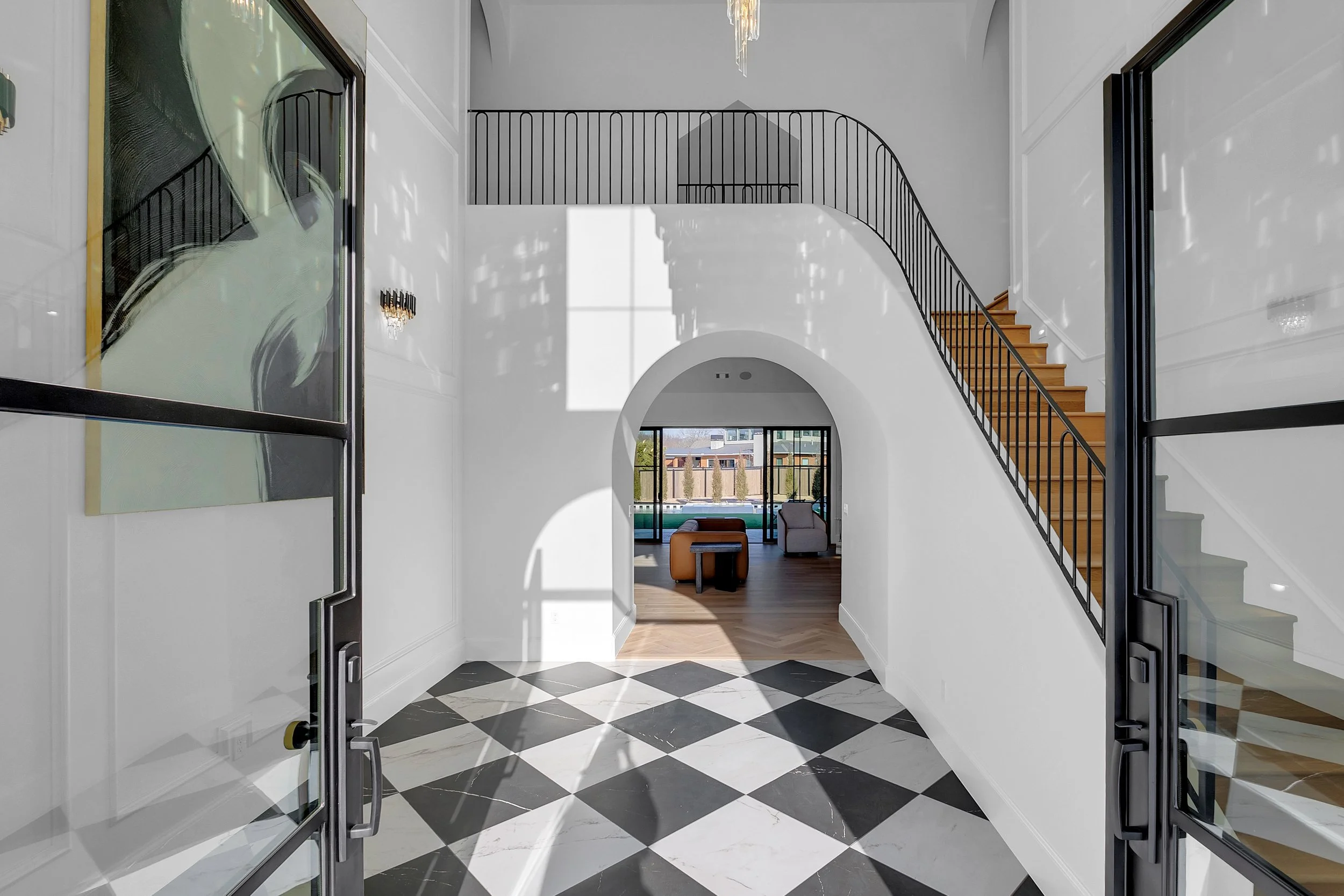 Luxury custom home staircase with curved design, wood treads, black metal railing, and refined architectural detailing.