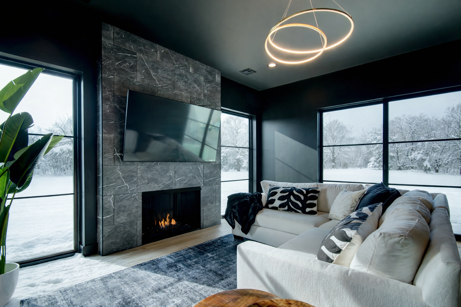 Luxury mountain modern living room with a custom fireplace, expansive windows, and tailored seating by Snow Peak Customs.