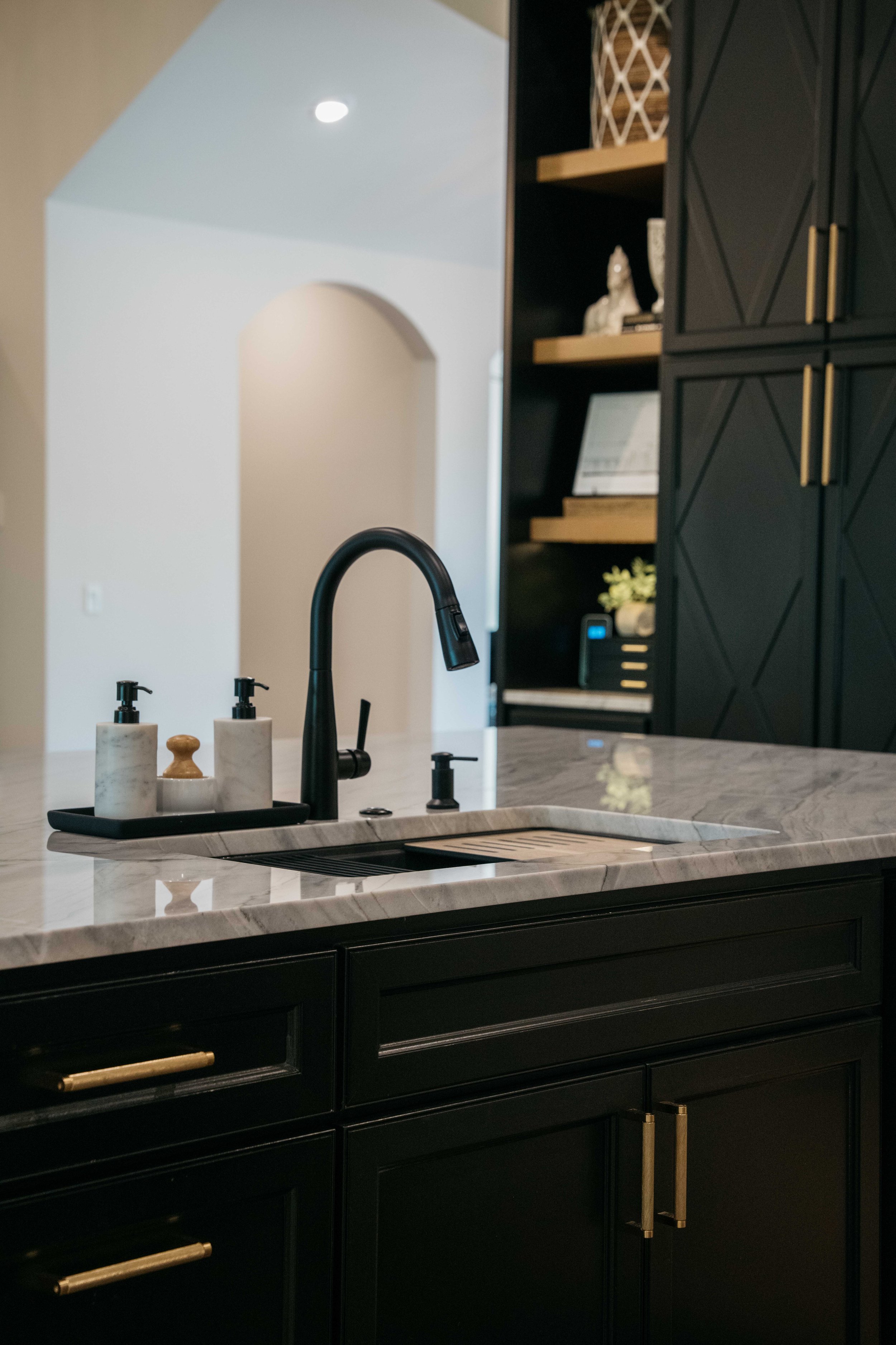 Custom kitchen cabinetry with marble countertop, matte black faucet, and refined hardware.