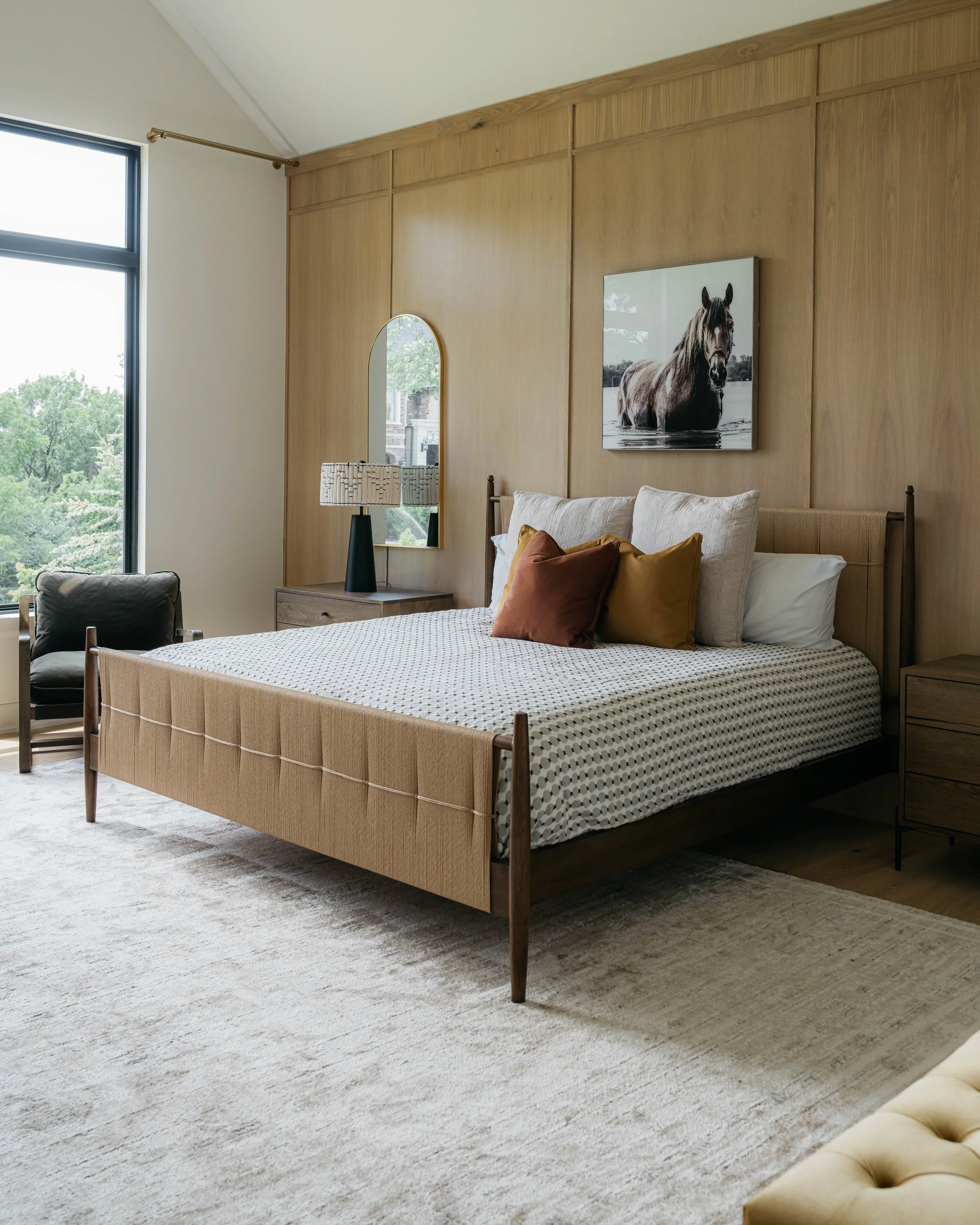 Luxury custom bedroom with wood panel accent wall, tailored furnishings, and warm modern design.