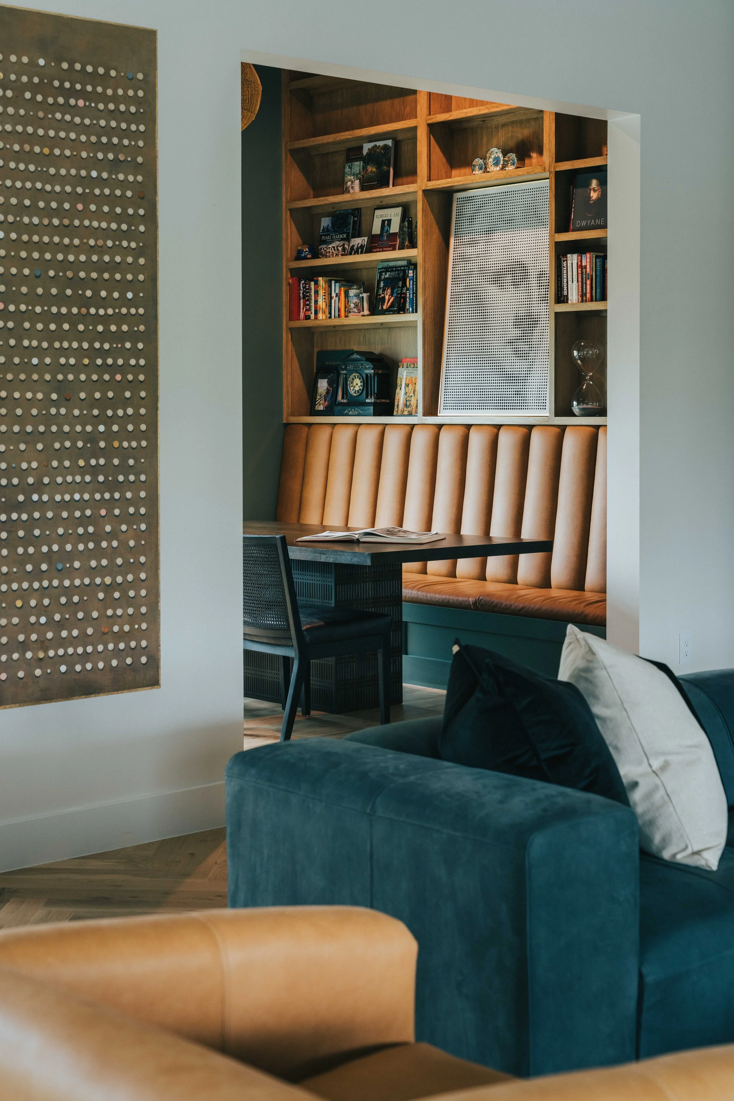 Custom mountain home interior with built-in wood shelving, leather banquette seating, and refined craftsmanship by Snow Peak Customs.