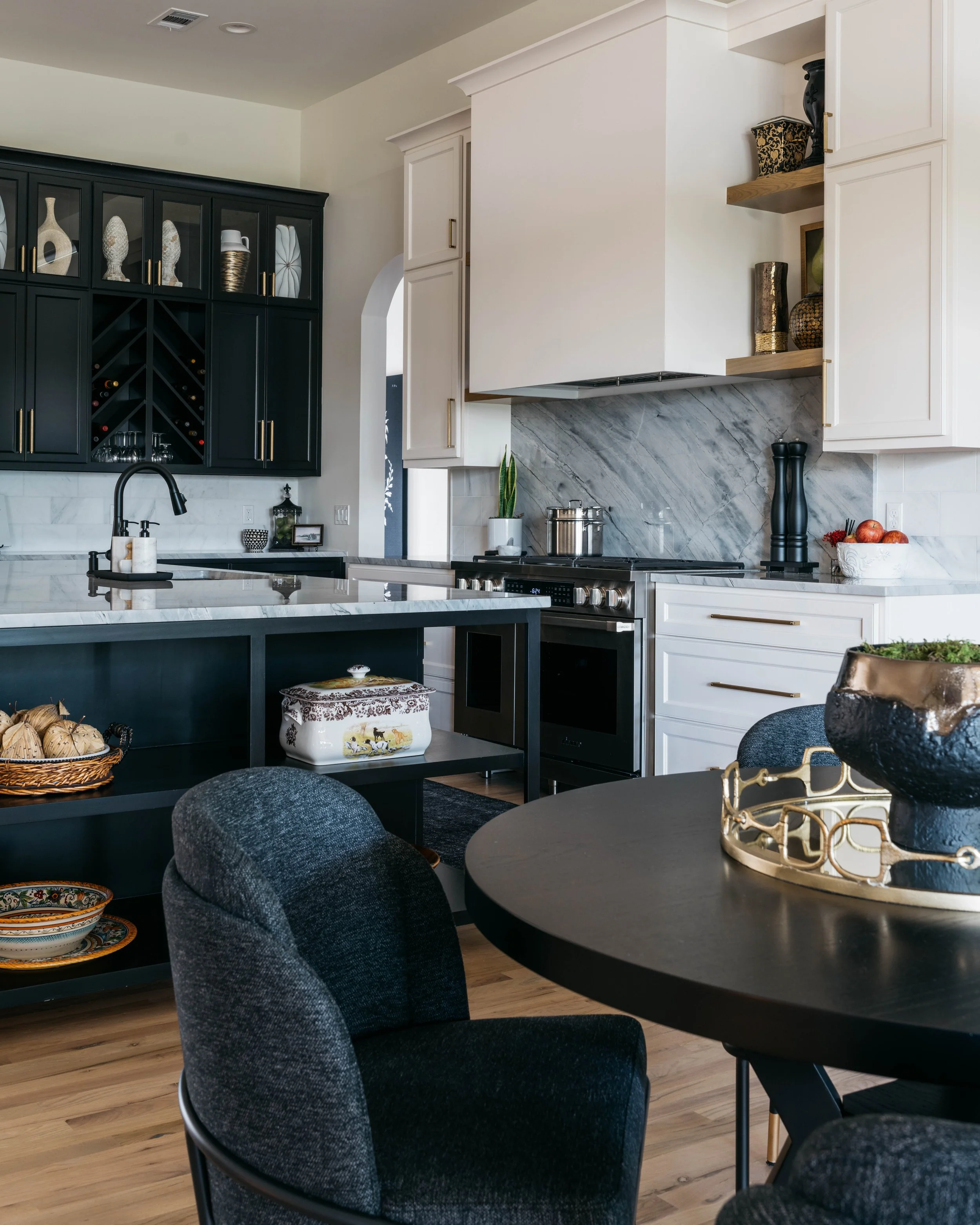 Luxury custom kitchen and dining space featuring tailored cabinetry, marble backsplash, and integrated wine storage.