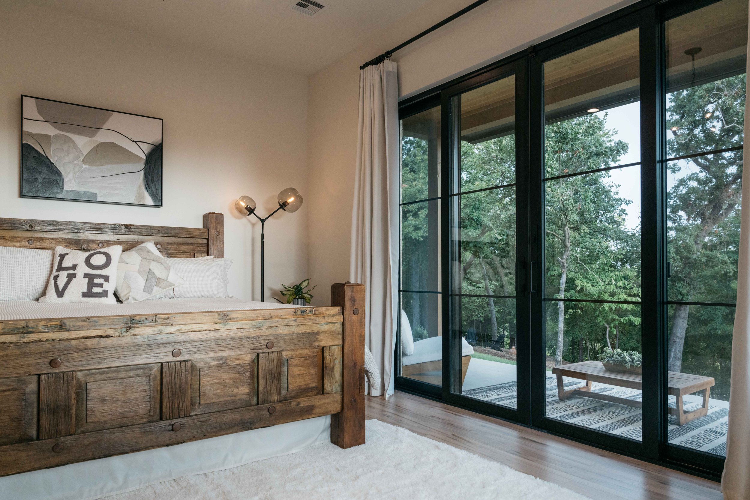 Custom mountain bedroom featuring a handcrafted wood bed, large windows, and warm, inviting design.