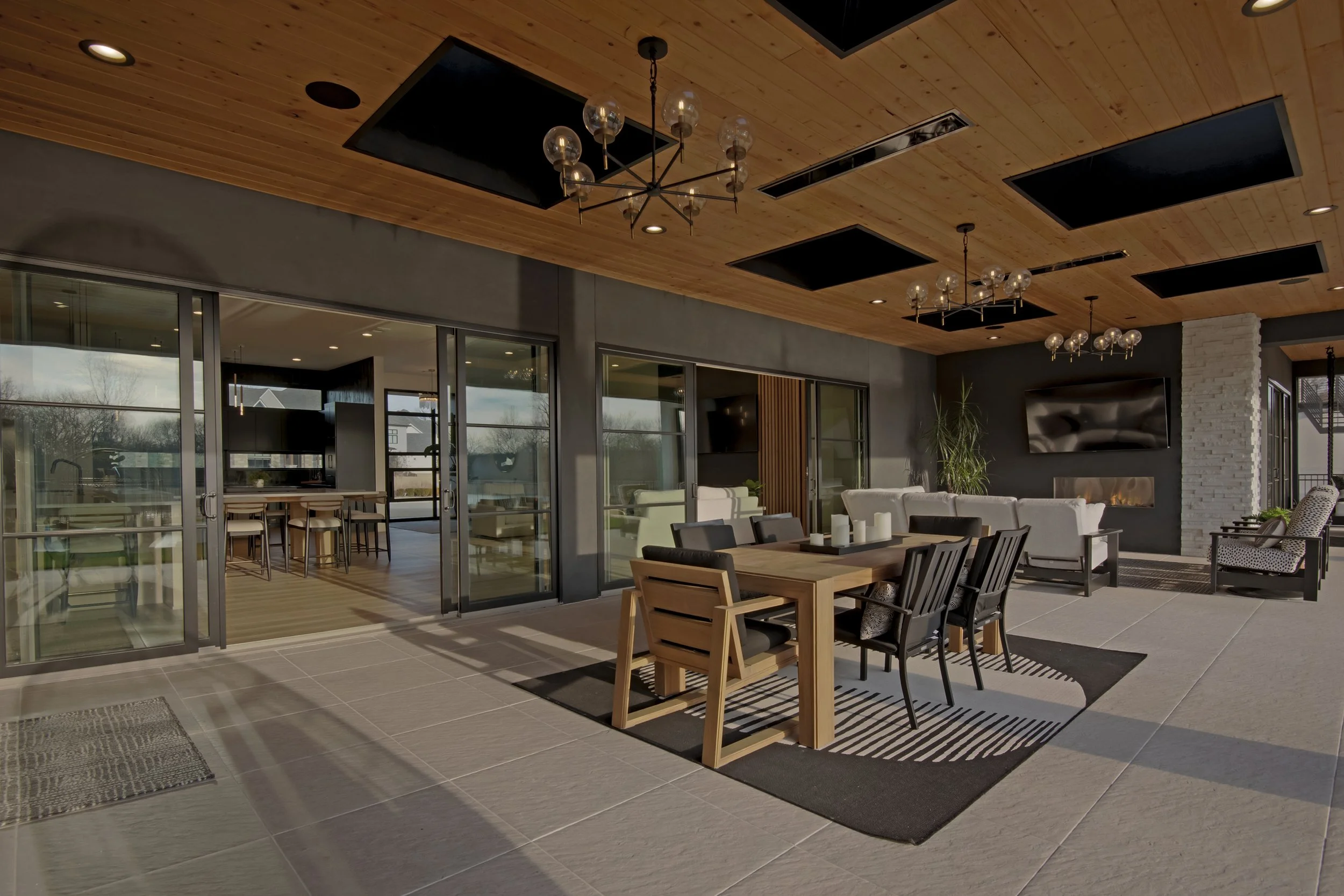 Luxury custom covered patio with outdoor dining, modern lighting, and seamless indoor–outdoor living.