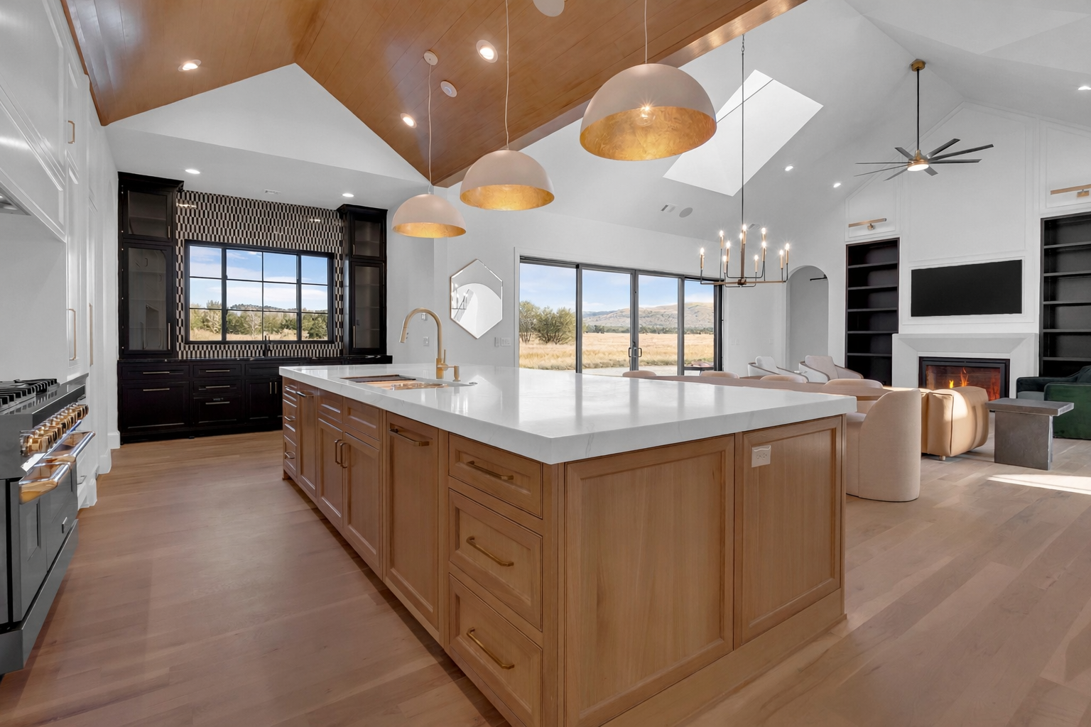 Luxury custom kitchen with a wood-clad island, stone countertops, and vaulted ceiling.