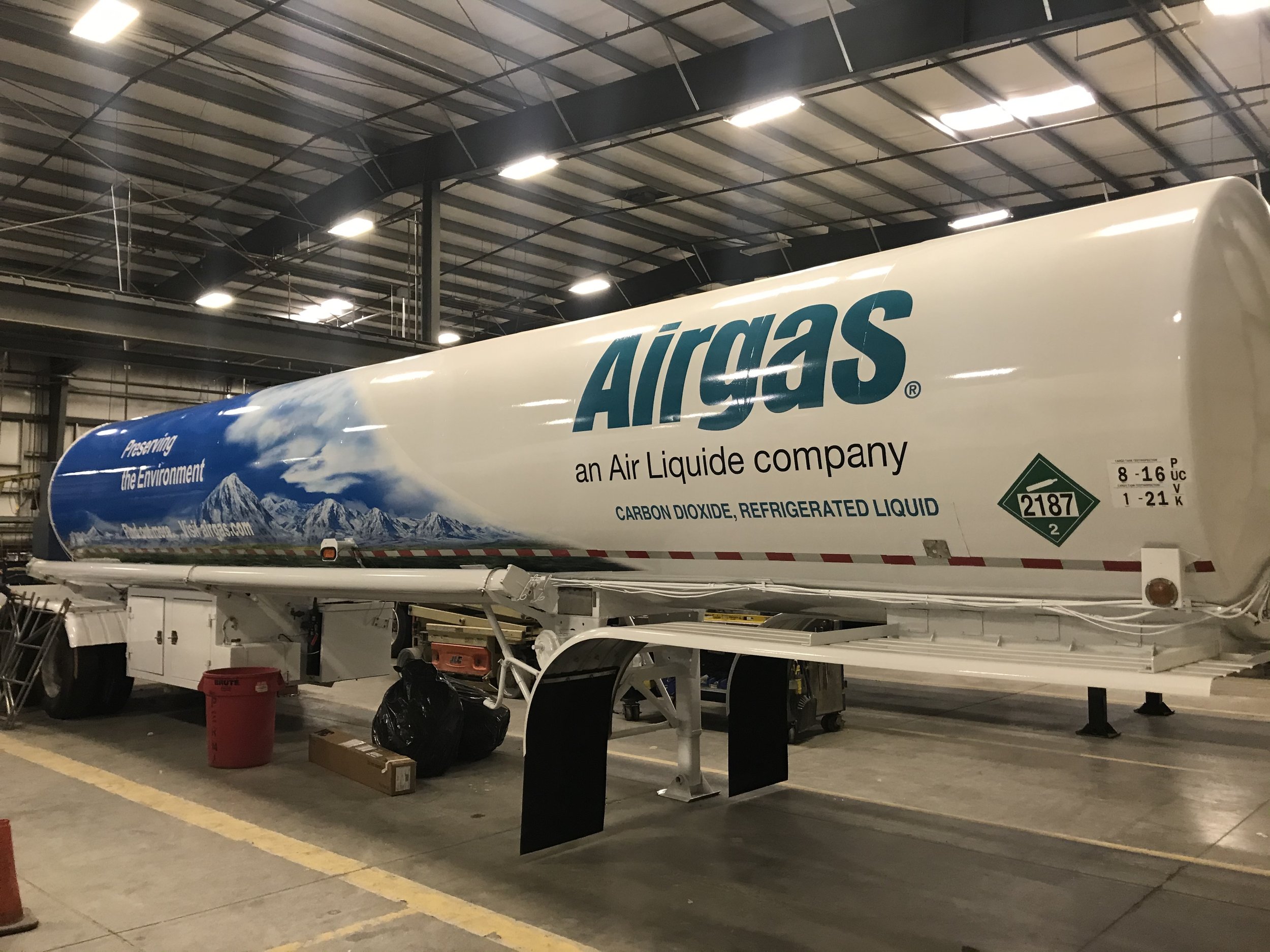 A cargo tanker inside a warehouse, labeled with Airgas logo, carrying compressed carbon dioxide liquid.
