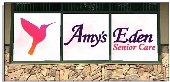 Sign for Amy's Eden Senior Care with a colorful hummingbird logo.