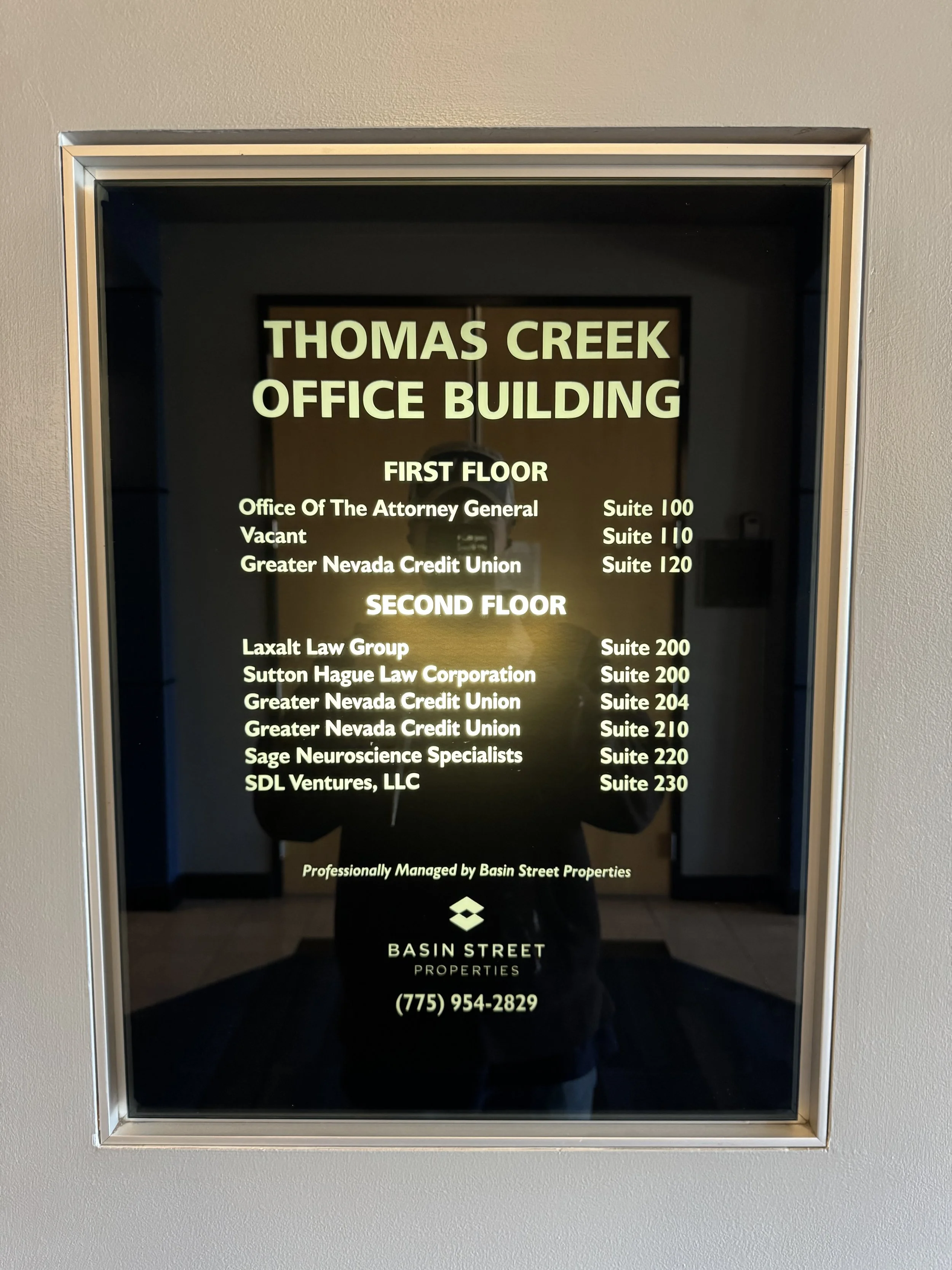 Directory display board for Thomas Creek Office Building listing offices and suite numbers on the first and second floors, including law firms, credit union, neuroscience specialists, and property management details.
