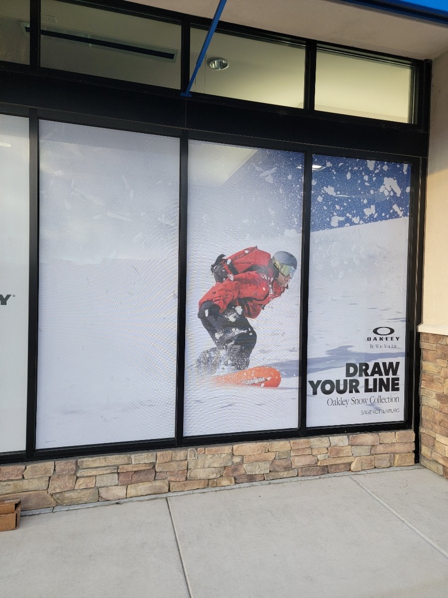 Advertisement window showing a person snowboarding in winter gear on a snowy slope with the text 'Draw Your Line Oakley Snow Collection' and the Oakley logo.