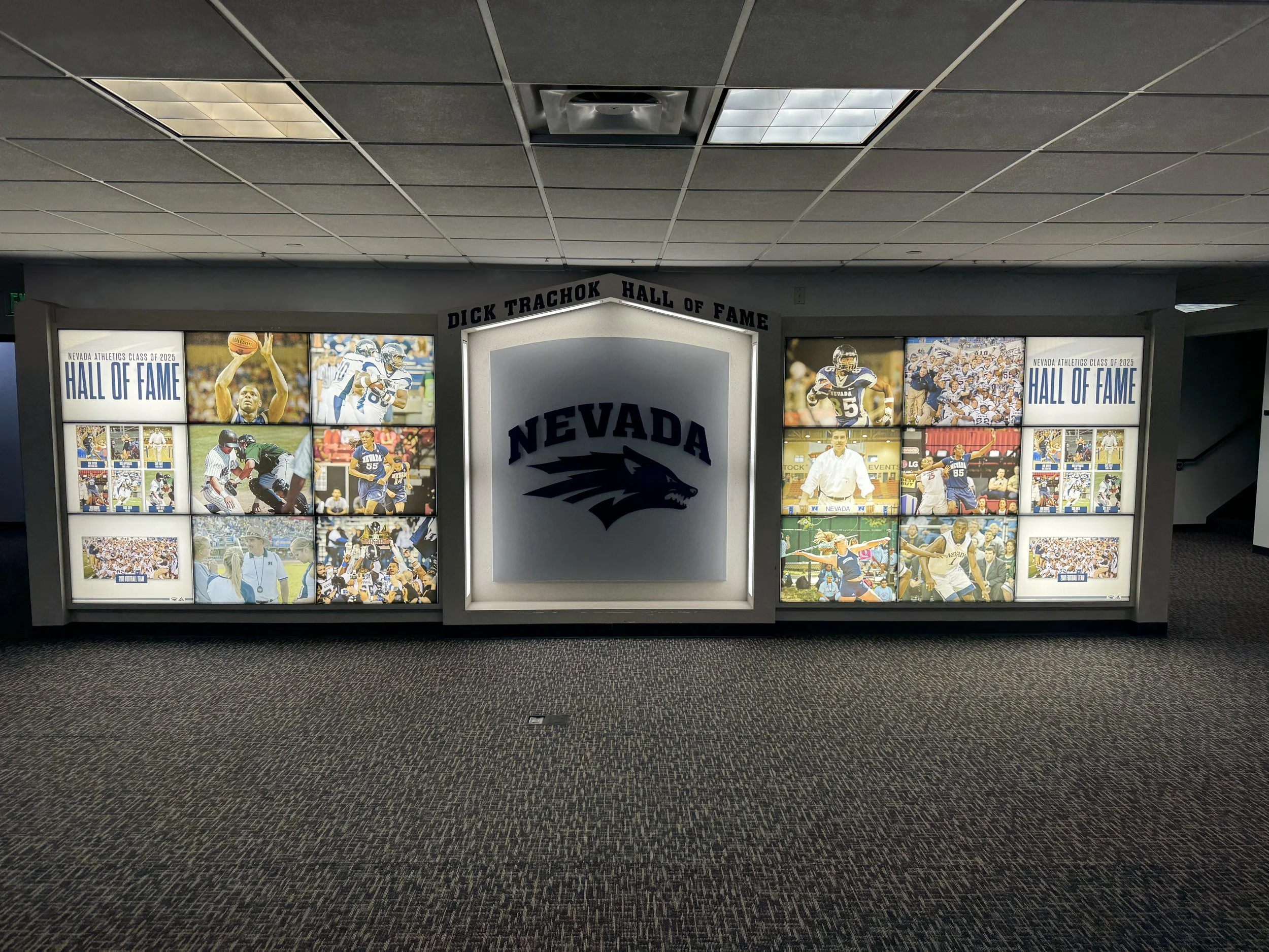 Nevada Hall of Fame display with photos of athletes and the Nevada logo in the center.