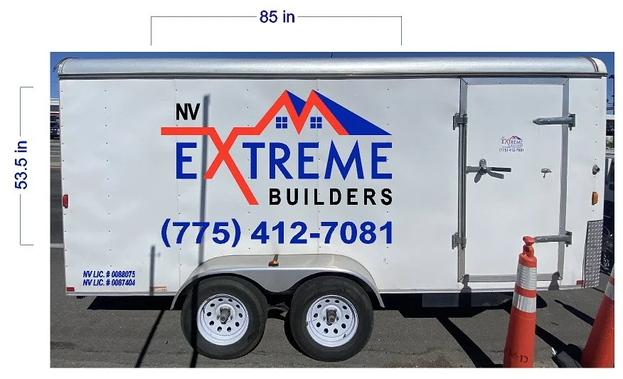 The image shows a white enclosed trailer with the logo and contact information for Nevada Extreme Builders on the side. The logo features a stylized mountain and house outline in red and blue, with the words "Nevada Extreme Builders" and a phone numb