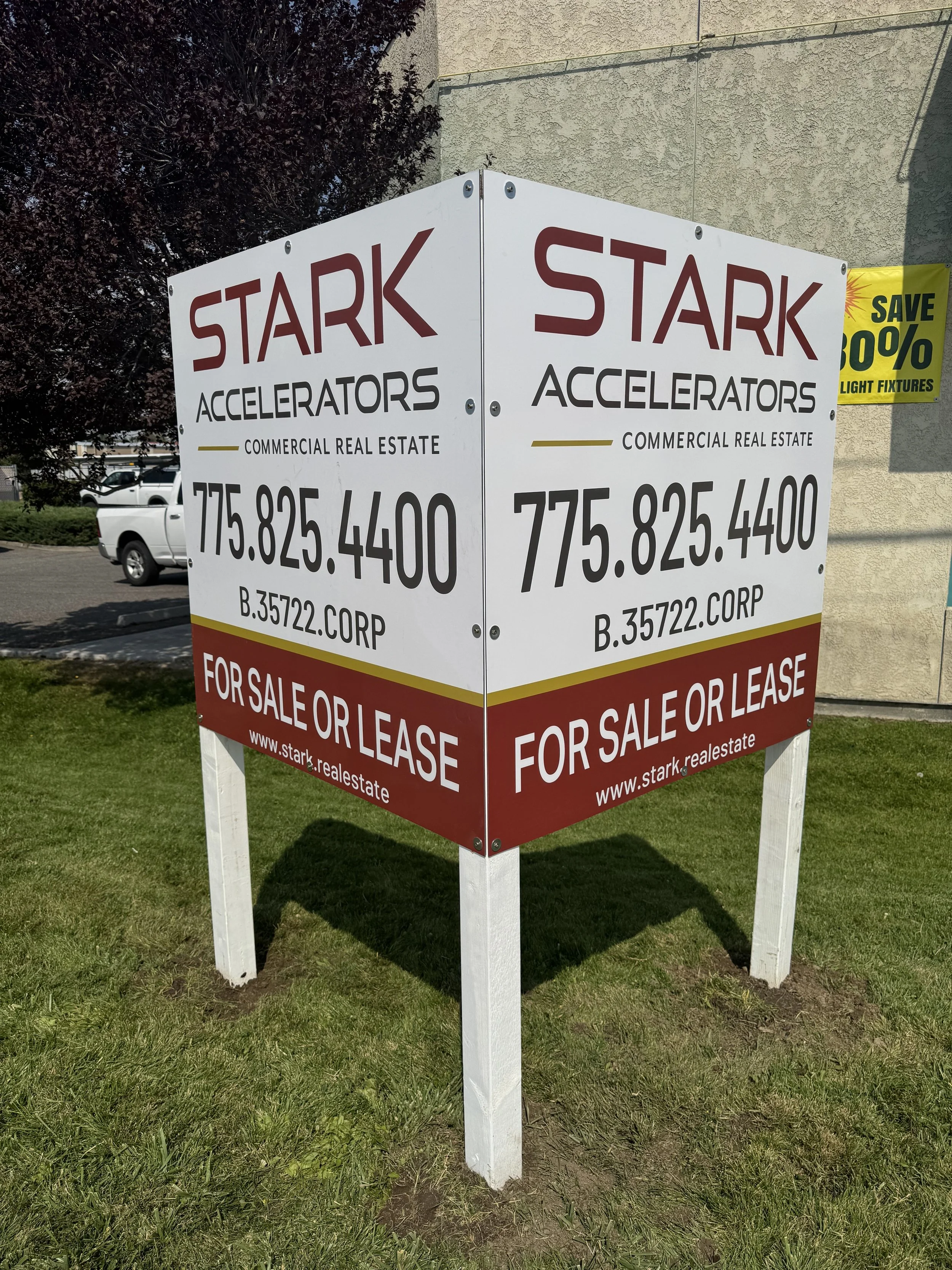 A large outdoor sign for Stark Accelerators advertising commercial real estate for sale or lease with contact information and a website.