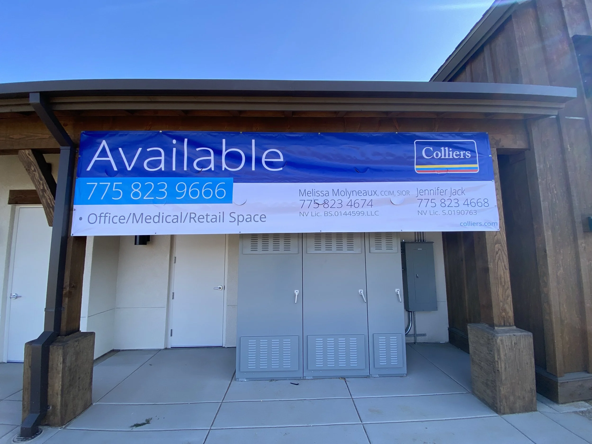 Signboard advertising office, medical, and retail space for rent, with contact details and company logo on a building exterior under clear blue sky.