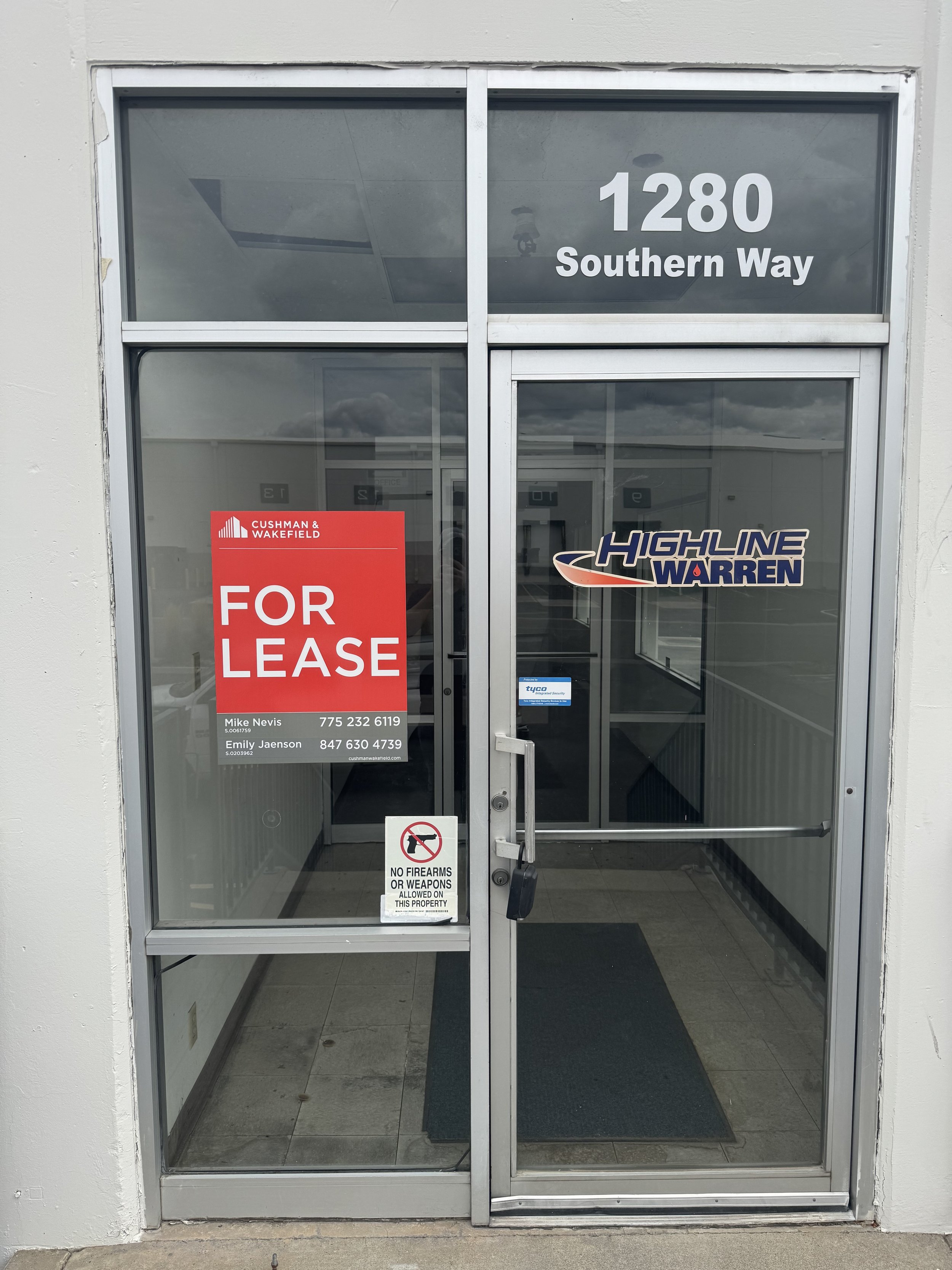 Glass door with address 1280 Southern Way, Highline Warren logo, Cushman & Wakefield For Lease sign, and a no firearms or weapons allowed sign.