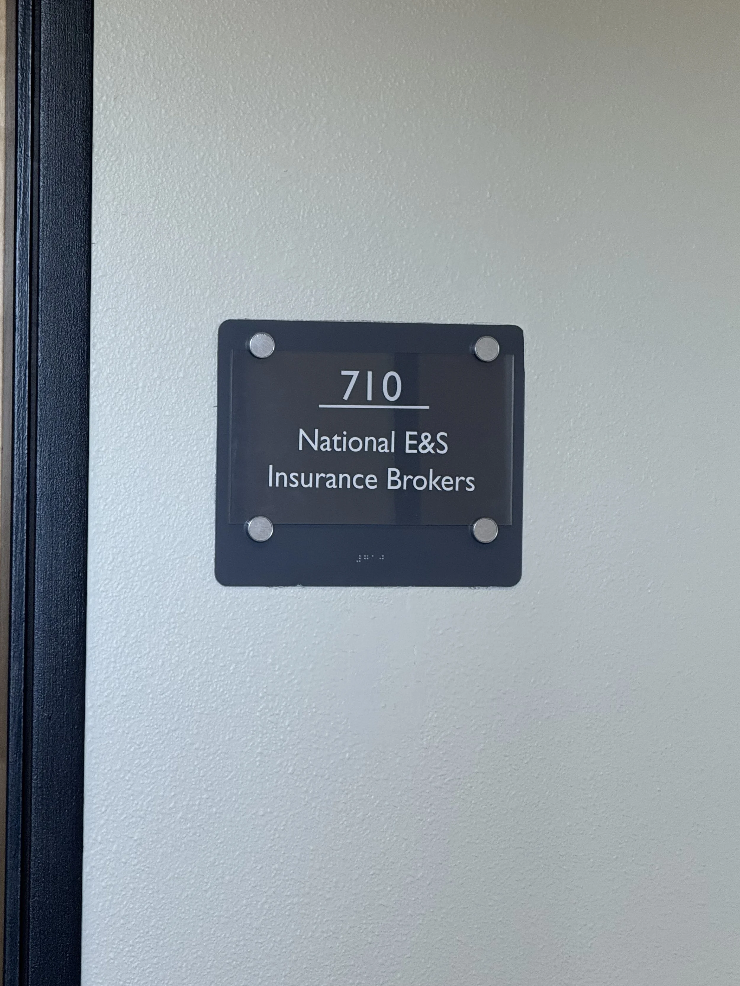 Office door sign with room number 710, for National E&S Insurance Brokers.