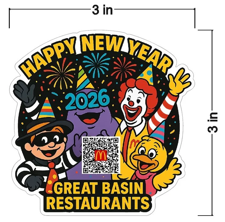 A colorful New Year's sticker with the text "HAPPY NEW YEAR," "2026," and "GREAT BASIN RESTAURANTS." It features cartoon characters including a woman with red hair, a friendly purple creature, a girl in a striped hat, and a yellow dog with a party ha