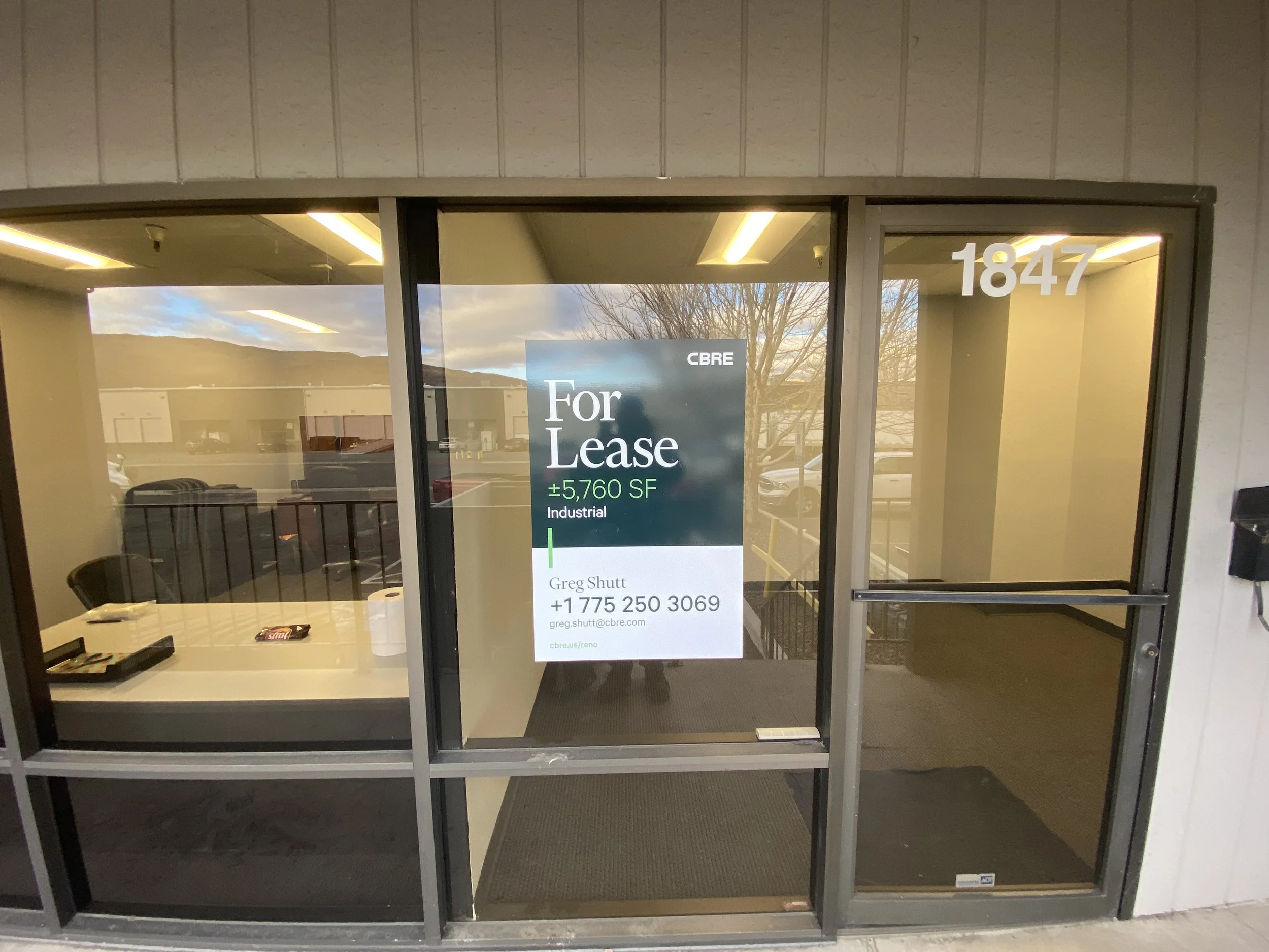 Empty office space for lease with a sign indicating 5,760 square feet available, contact information, and a street address 1847.