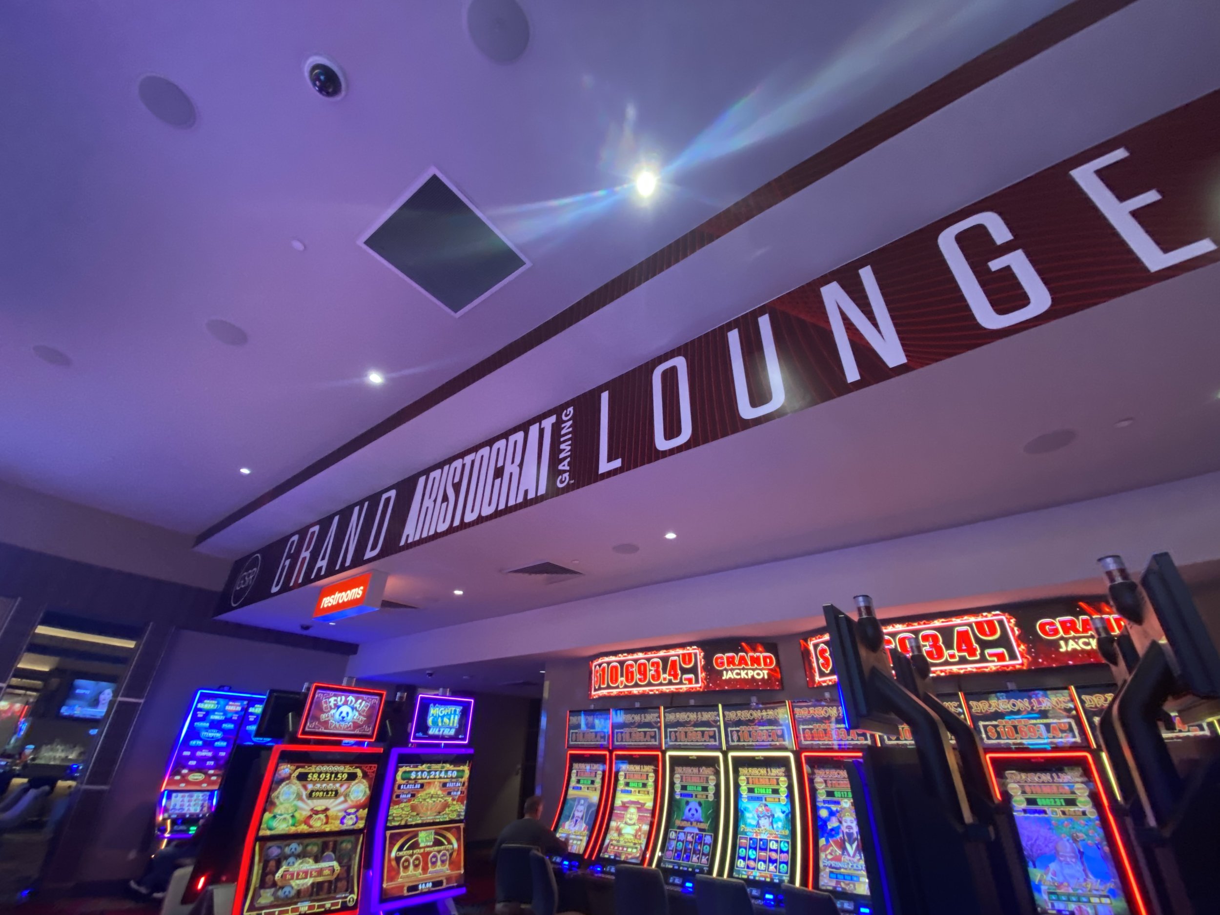 Casino with slot machines and a grand lounge sign overhead