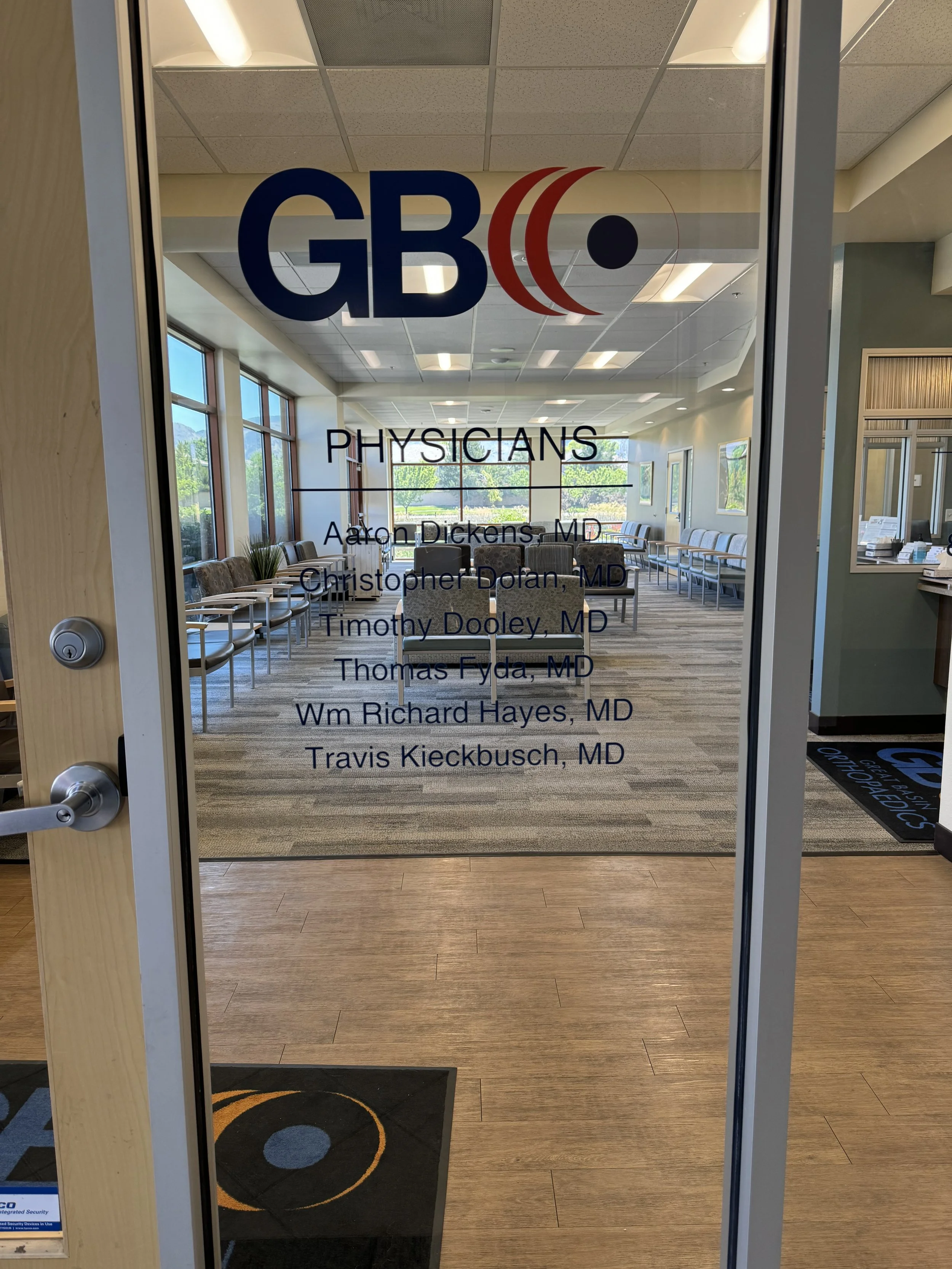 Glass door to a medical office with the GBC Physicians logo and the names of six doctors listed underneath.