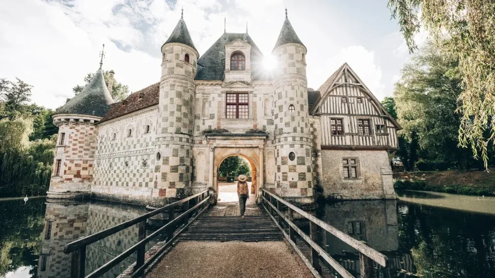 Moated Norman castle with half-timbered gatehouse