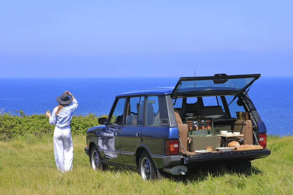 Vintage Land Rover parked above the sea