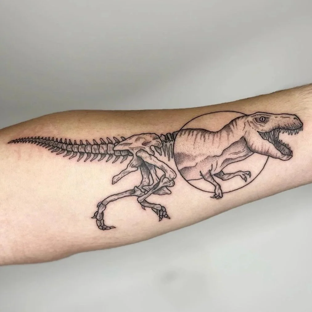 Tattoo of a T-Rex dinosaur with a part of the skeleton visible and a circle around the head, depicted on a person's arm.