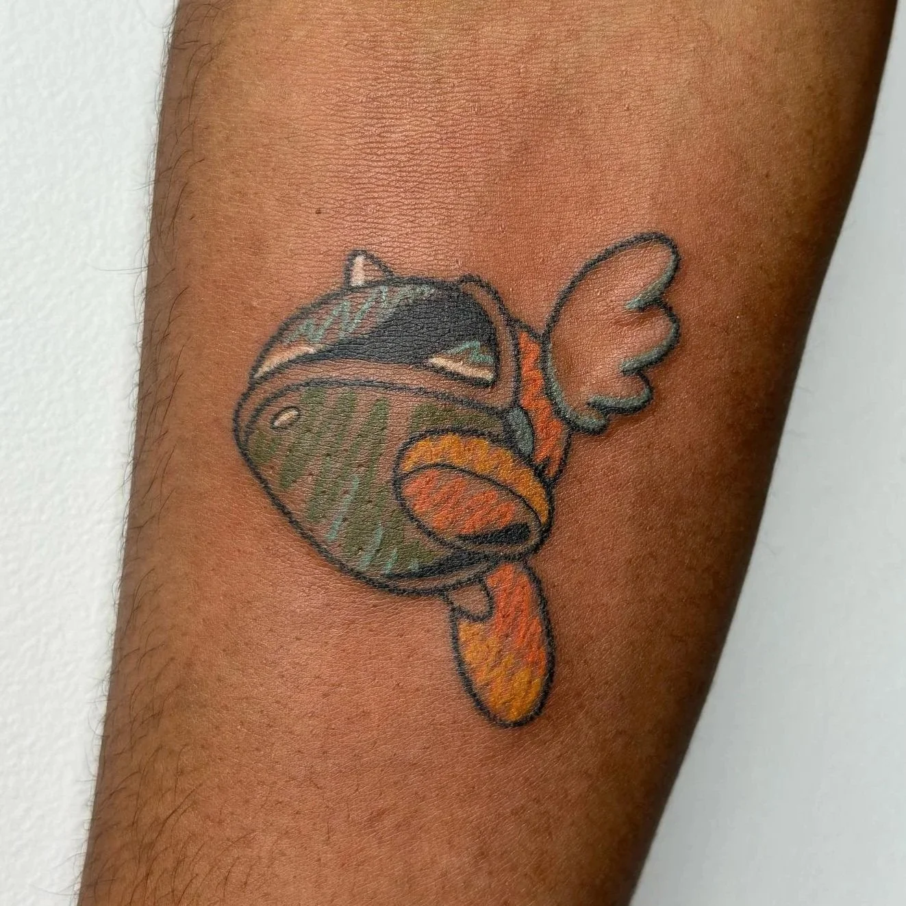 A colorful tattoo of a turtle with butterfly wings.