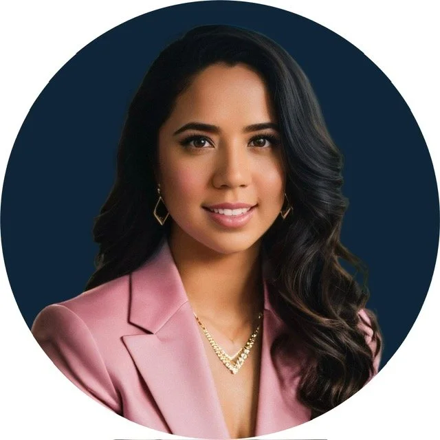 A young woman with long dark wavy hair, wearing a pink blazer, gold jewelry, and earrings, smiling against a dark blue circular background.