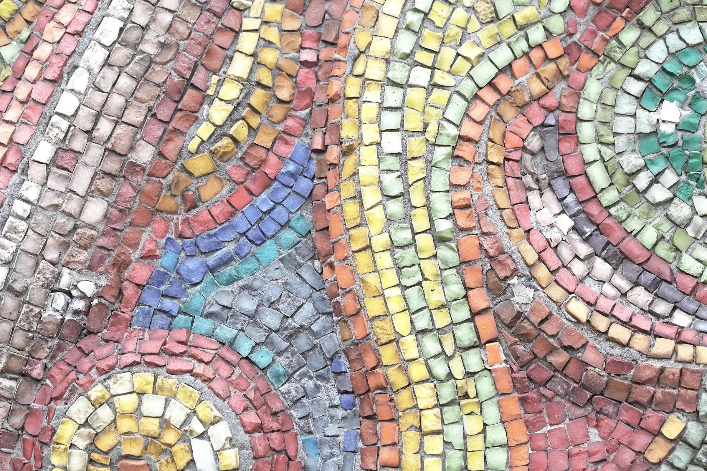 Colorful mosaic made of small, square stones arranged in swirling patterns.