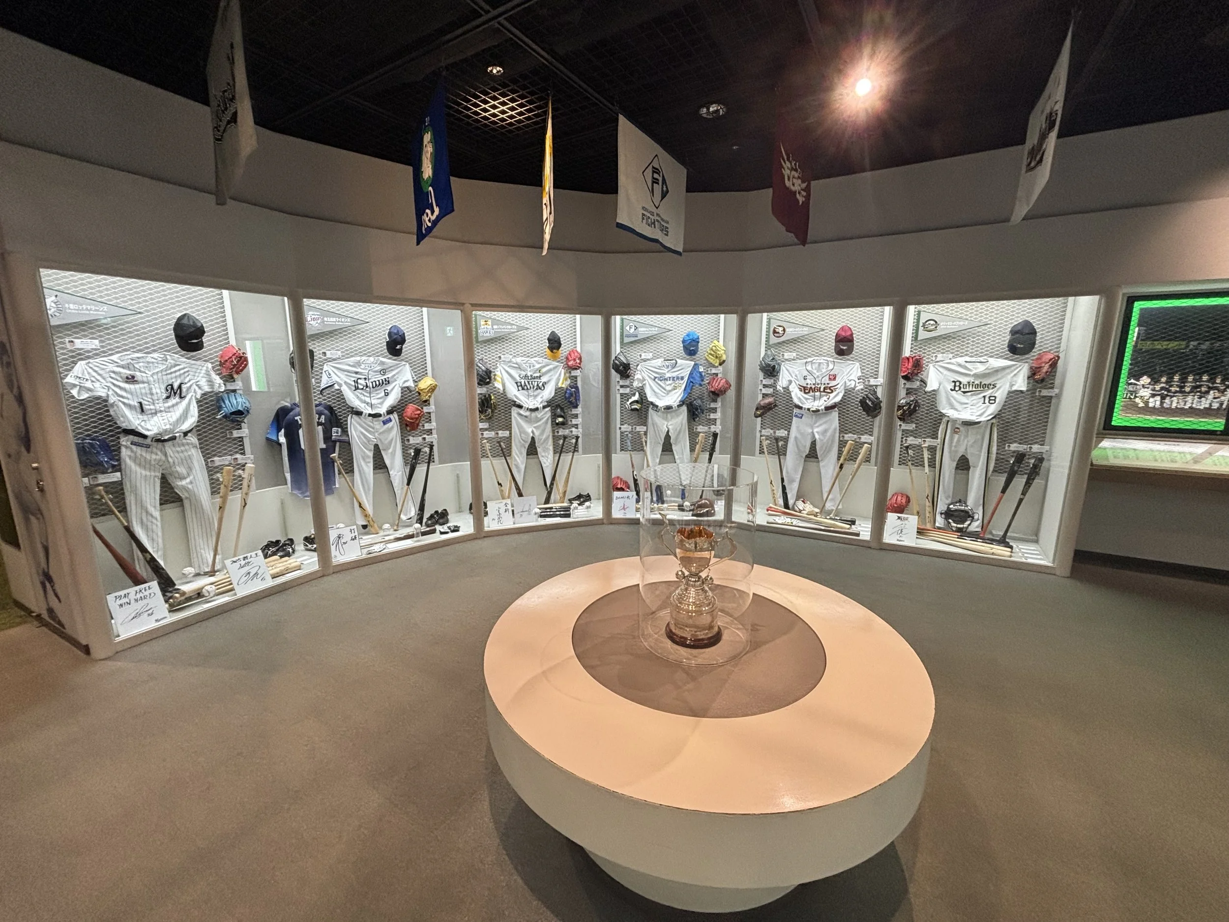 Baseball hall of fame in tokyo view of 6 team outfits and other items.