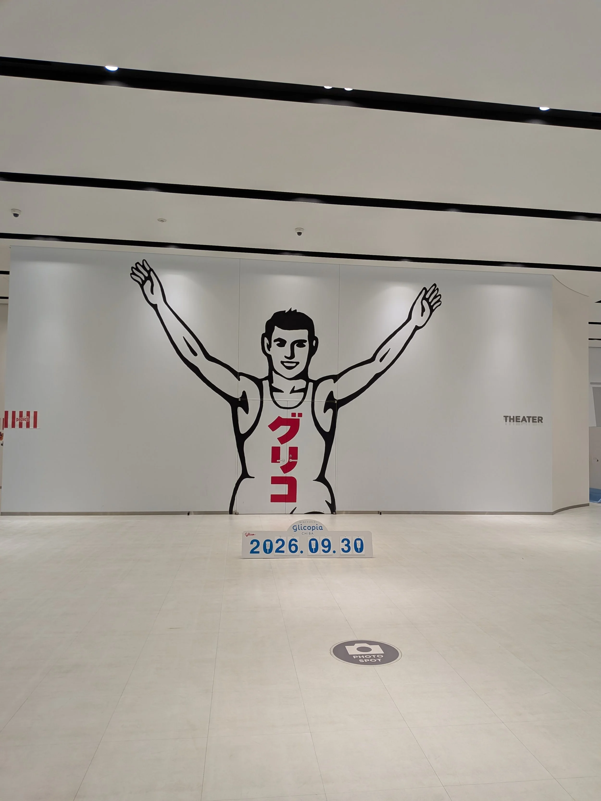 Picture of the Glico, black and white running man outline inside a corporate museum.