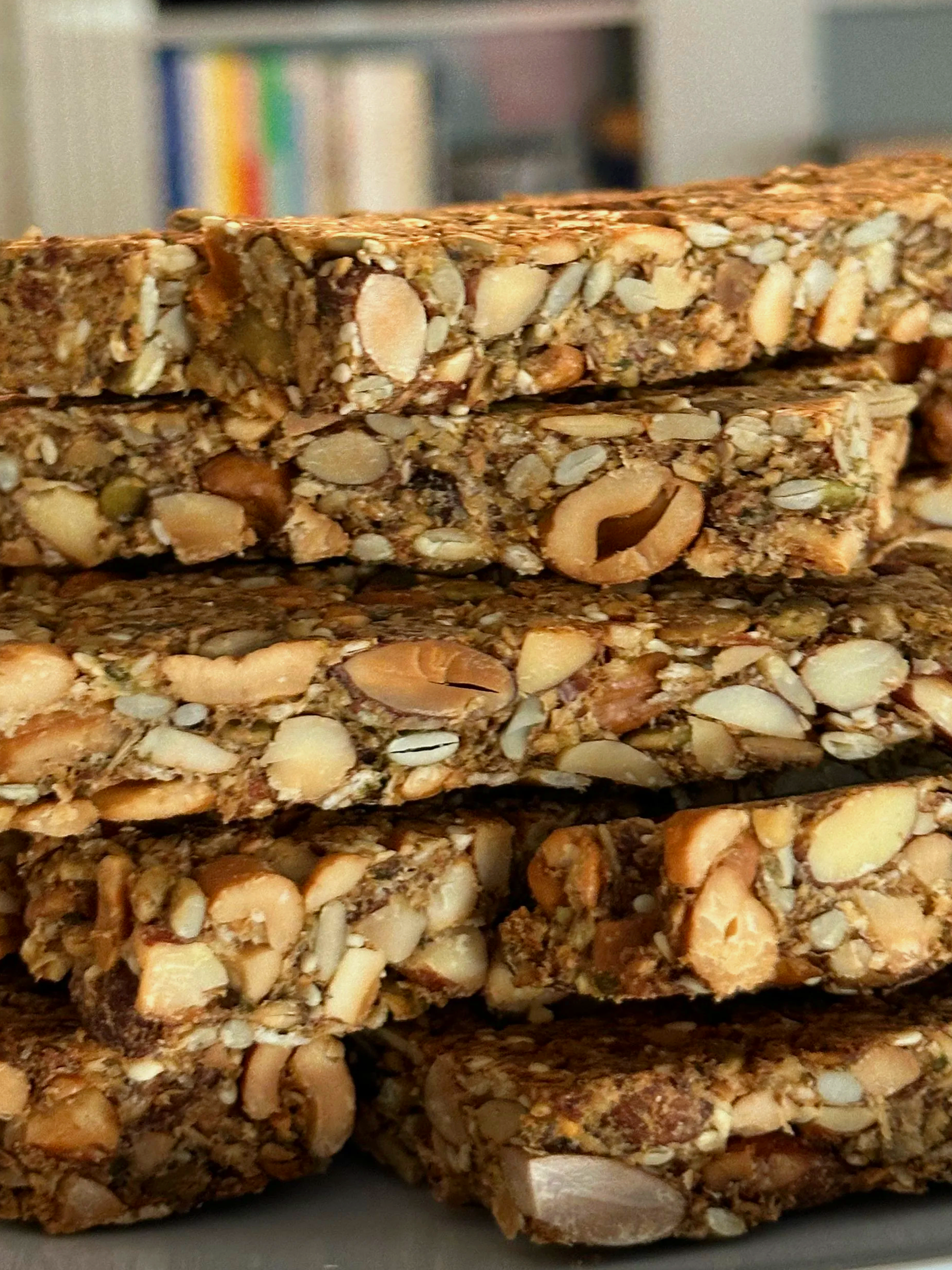 Close-up of several homemade nut and seed granola bars stacked together.