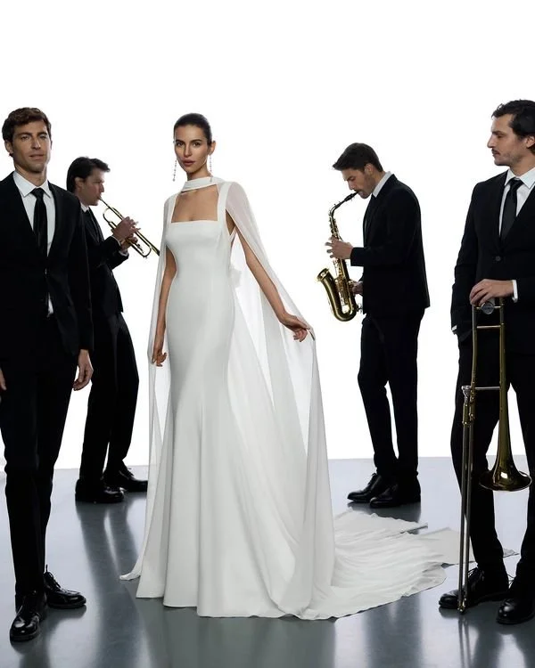 Long two-piece mermaid wedding dress in bi-elastic crepe. Square neckline, straps, and open back. With fine georgette cape.