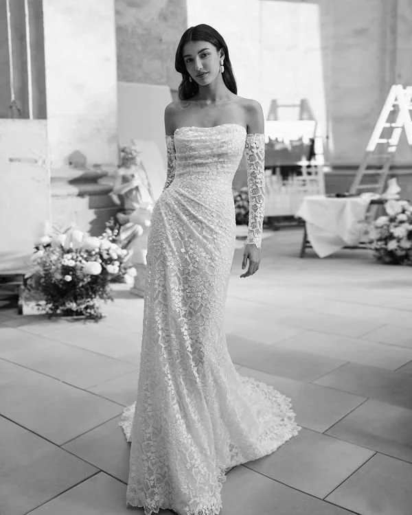 Bridal gown, mermaid silhouette. Made of lace. Strapless neckline, detachable sleeves, and open back.