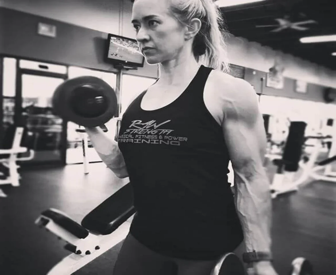 A woman lifting dumbbells at the gym.