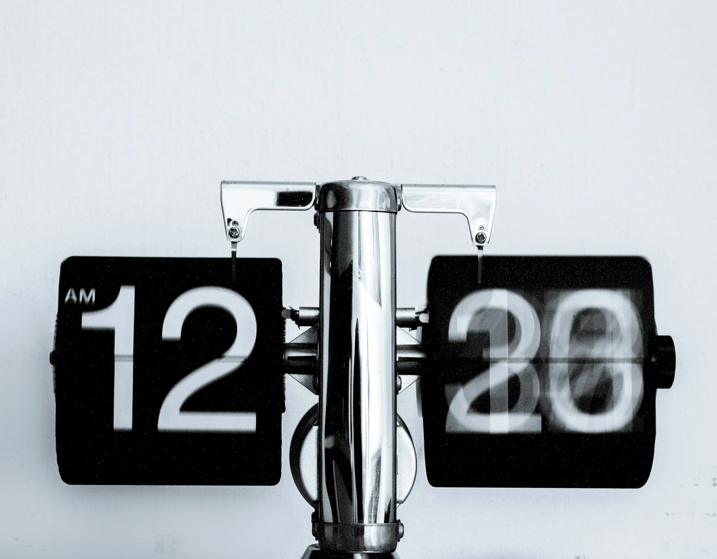 Close-up of a vintage black and white clock face with bold numbers and clock hands.