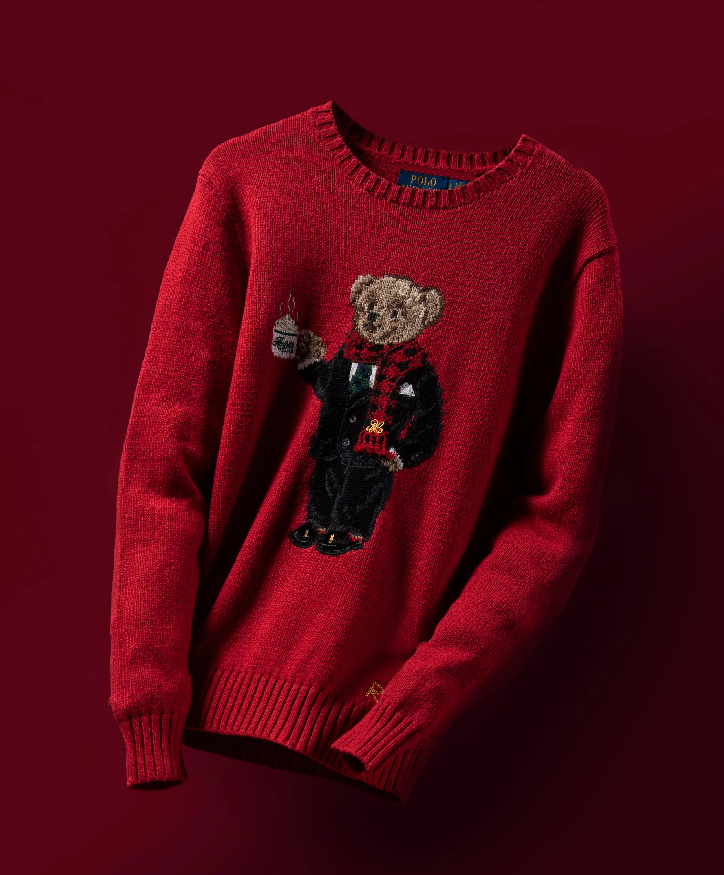 Red sweater with a teddy bear holding a coffee cup and a bottle, featuring a Christmas or holiday design.